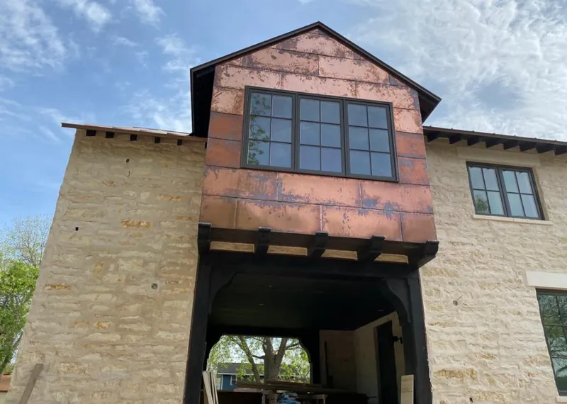 Copper metal panel facade on a stone building for Skylight Installation in Coronado