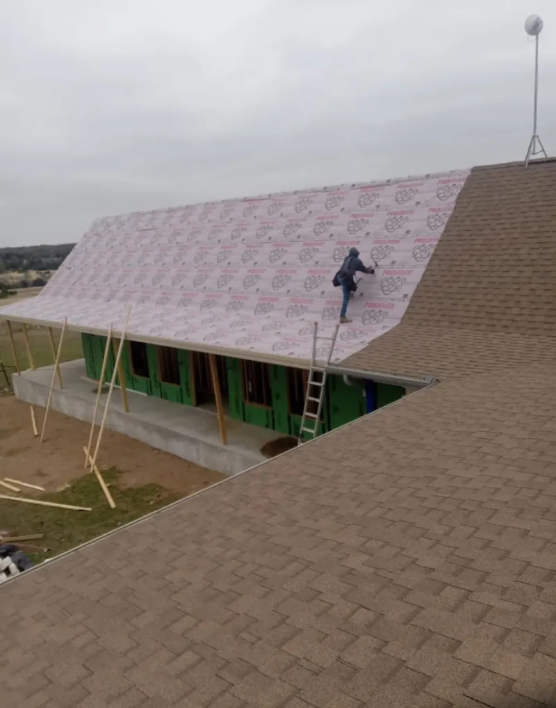 Worker preparing underlayment for a metal roof installation in Coronado
